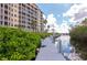 Beautiful dock next to building lined with greenery and tropical landscaping at 5561 Cannes Cir # 5101, Sarasota, FL 34231