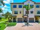 Inviting townhouse exterior featuring a brick driveway, lush landscaping, and attractive architectural details at 5561 Cannes Cir # 5101, Sarasota, FL 34231