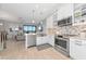 Open kitchen with stainless steel appliances, white cabinets, and views of the living area at 5561 Cannes Cir # 5101, Sarasota, FL 34231