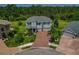 Aerial view of a well-manicured home featuring a three-car garage and lush landscaping with beautiful palm trees at 5805 49Th E Ct, Ellenton, FL 34222