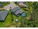 Aerial view of a home with a screened pool, trampoline, spacious backyard, and lush surroundings at 5805 49Th E Ct, Ellenton, FL 34222