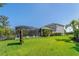 Fenced backyard featuring large screened enclosure, expansive green lawn, and mature trees at 5805 49Th E Ct, Ellenton, FL 34222