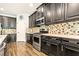 Well-lit kitchen featuring stainless steel appliances, mosaic backsplash, and dark wood cabinets at 5805 49Th E Ct, Ellenton, FL 34222