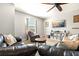 A living room with couches, side tables, neutral carpet, a ceiling fan, TV, and natural light offering a relaxing space at 5805 49Th E Ct, Ellenton, FL 34222