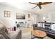 A living room featuring couches, a ceiling fan, carpet, a television, and neutral paint to create a comfortable and stylish space at 5805 49Th E Ct, Ellenton, FL 34222