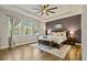 Spacious main bedroom with a tray ceiling, hardwood floors, and large windows overlooking the yard at 5805 49Th E Ct, Ellenton, FL 34222