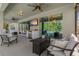 Inviting outdoor lounge area with plush seating, outdoor television, and a scenic view of the lush backyard at 5805 49Th E Ct, Ellenton, FL 34222