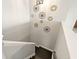A stairway with dark wood steps and white walls decorated with various art pieces, lit by an overhead light fixture at 5805 49Th E Ct, Ellenton, FL 34222