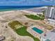 Aerial view of community pool and beach access, highlighting manicured landscaping and nearby residential buildings at 5858 Midnight Pass Rd # 27, Sarasota, FL 34242