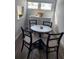 Bright breakfast nook with a round table, woven chairs, and a small sideboard at 5858 Midnight Pass Rd # 27, Sarasota, FL 34242