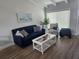Cozy living room featuring a blue sofa, coastal decor, and wood-look flooring at 5858 Midnight Pass Rd # 27, Sarasota, FL 34242