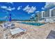 Inviting pool area with sun loungers and patio furniture, complemented by palm trees and ocean views at 5858 Midnight Pass Rd # 27, Sarasota, FL 34242