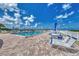 Relaxing pool area with sun loungers, tables, and beach views offering a perfect spot for leisure at 5858 Midnight Pass Rd # 27, Sarasota, FL 34242