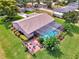 Aerial view of sparkling screened pool, patio and manicured landscaping at 6011 91St E St, Bradenton, FL 34202