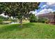 Serene backyard view with mature trees, lush lawn, and waterfront access at 6011 91St E St, Bradenton, FL 34202