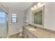 Bright bathroom with granite countertop vanity, shower with glass door, and tile flooring at 6011 91St E St, Bradenton, FL 34202