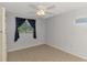 Cozy bedroom with tile flooring, a ceiling fan, window, built-in storage, and neutral colored walls at 6011 91St E St, Bradenton, FL 34202