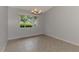 Dining area featuring tile floors, a chandelier, and a window with a lush, green view at 6011 91St E St, Bradenton, FL 34202