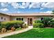 Inviting front entrance featuring a well-manicured lawn, mature landscaping, and a charming pathway at 6011 91St E St, Bradenton, FL 34202