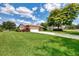 Beautiful home with green lawn, landscaping and mature trees creating a welcoming exterior at 6011 91St E St, Bradenton, FL 34202