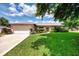 Well-maintained single-story home with lush green lawn, an attached two-car garage and charming landscaping at 6011 91St E St, Bradenton, FL 34202
