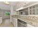 Bright kitchen with white cabinets, mosaic backsplash, granite countertops and stainless dishwasher at 6011 91St E St, Bradenton, FL 34202