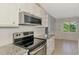 Open kitchen with stainless oven and microwave, granite counters, and tile floors at 6011 91St E St, Bradenton, FL 34202
