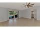 Spacious living room with tile flooring, ceiling fan, and sliding glass doors with a pool view at 6011 91St E St, Bradenton, FL 34202