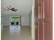 Open-concept living room with neutral tile flooring, a ceiling fan, and sliding glass doors to the lanai at 6011 91St E St, Bradenton, FL 34202