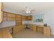 Home office with custom built-in shelves, cabinets, drawers, a ceiling fan and large windows at 6011 91St E St, Bradenton, FL 34202