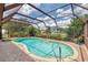 Sparkling pool in screened-in lanai offers a refreshing oasis with lush landscaping and ample sunshine at 6011 91St E St, Bradenton, FL 34202