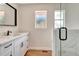 Bathroom featuring a white vanity with black fixtures, glass enclosed shower, and hardwood floors at 609 25Th W Ave, Bradenton, FL 34205