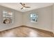 Bedroom featuring hardwood floors, neutral walls, white trim, ceiling fan, and large windows at 609 25Th W Ave, Bradenton, FL 34205