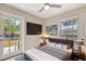Modern bedroom with a plush bed, mounted tv, ceiling fan and bright windows at 609 25Th W Ave, Bradenton, FL 34205