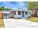Charming home with a carport and driveway, featuring light-blue siding and well-maintained landscaping at 609 25Th W Ave, Bradenton, FL 34205
