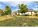 Picturesque backyard featuring lush green grass, mature trees, and a charming patio area at 6102 9Th Avenue Cir Ne, Bradenton, FL 34212