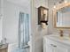 Well-lit bathroom with shower, vanity, and decorative shelving with a towel rack at 6102 9Th Avenue Cir Ne, Bradenton, FL 34212