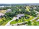 Aerial view shows a well-maintained property featuring lush landscaping, mature trees, and a circular driveway at 6102 9Th Avenue Cir Ne, Bradenton, FL 34212
