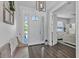 Inviting foyer featuring wood floors, a bench, and a view into the home's bedroom at 6102 9Th Avenue Cir Ne, Bradenton, FL 34212
