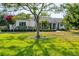 Inviting single-story home showcasing a well-manicured lawn, complemented by mature trees and landscaping at 6102 9Th Avenue Cir Ne, Bradenton, FL 34212