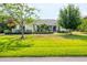 Charming single-story home showcasing a well-manicured lawn, complemented by mature trees and landscaping at 6102 9Th Avenue Cir Ne, Bradenton, FL 34212