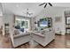 Bright living room with vaulted ceilings, ceiling fans, sliding glass doors, and hardwood flooring at 6102 9Th Avenue Cir Ne, Bradenton, FL 34212