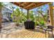 Outdoor deck featuring a grill, seating area, and lush landscaping in a tranquil backyard setting at 6250 Holmes Blvd # 63, Holmes Beach, FL 34217