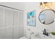 Clean bathroom featuring a toilet, sink, mirror, and a storage closet with a stylish nautical theme at 6250 Holmes Blvd # 63, Holmes Beach, FL 34217