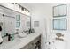 Modern bathroom with double sink vanity, beautiful tile shower and beachy decor at 6250 Holmes Blvd # 63, Holmes Beach, FL 34217