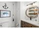 Bathroom with updated vanity, nautical decor, and a round mirror with wood accents at 6250 Holmes Blvd # 63, Holmes Beach, FL 34217