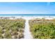 Scenic sandy path to the beach with native dune grasses and calm ocean at 6250 Holmes Blvd # 63, Holmes Beach, FL 34217