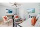 Cozy bedroom with tile floors, soft blue walls, a ceiling fan, comfortable seating and wall mounted television at 6250 Holmes Blvd # 63, Holmes Beach, FL 34217
