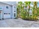 Townhome exterior with a garage, lush landscaping, and inviting curb appeal in a tropical setting at 6250 Holmes Blvd # 63, Holmes Beach, FL 34217