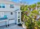 The light blue home exterior boasts a balcony, tropical landscaping, and garage at 6250 Holmes Blvd # 63, Holmes Beach, FL 34217